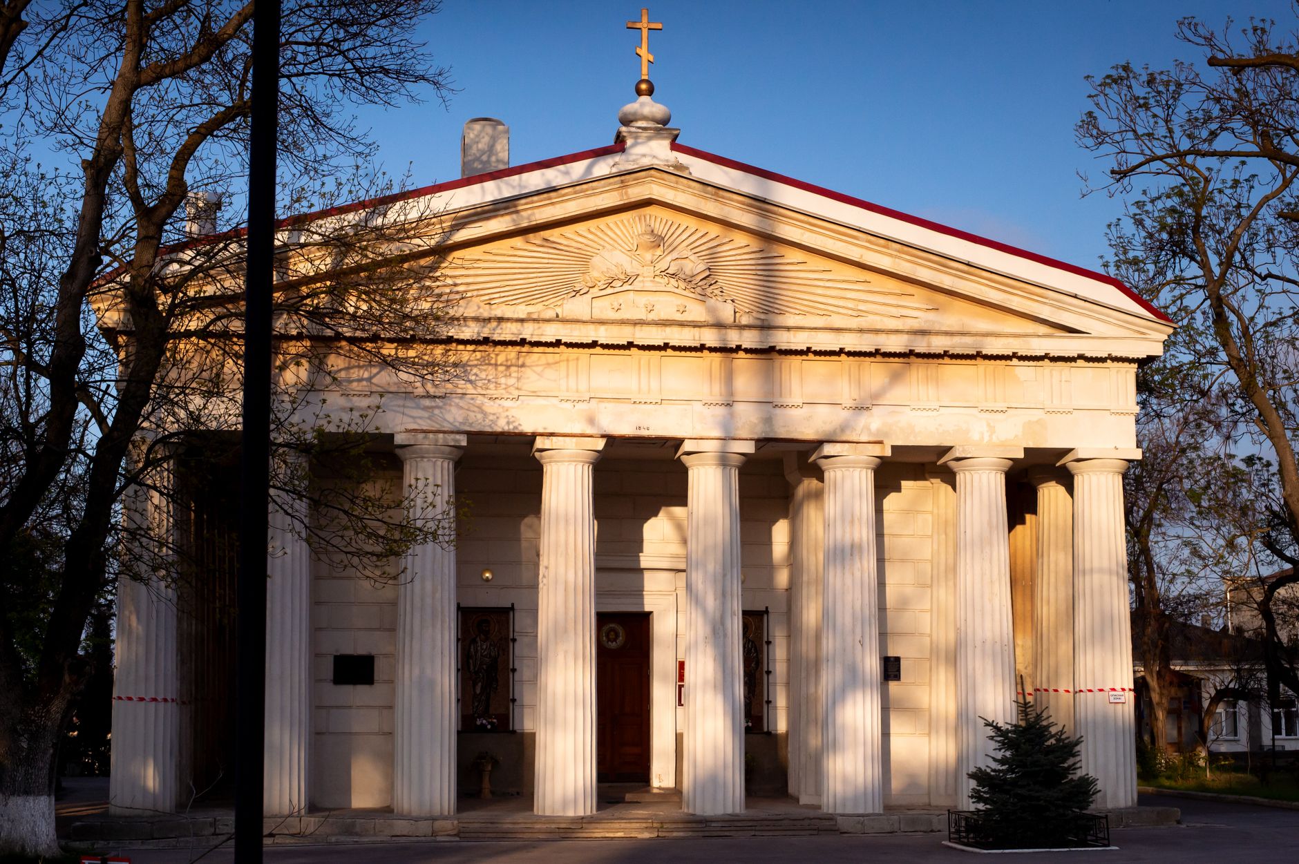 A stunning neoclassical church facade with Corinthian columns in warm evening light