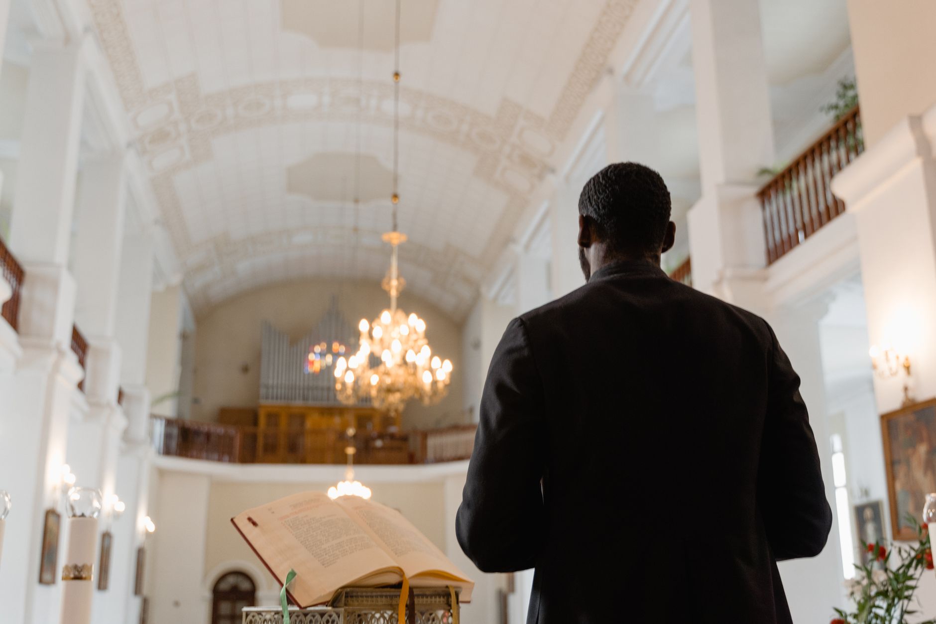 A priest delivering a sermon in a beautifully ornate church interior